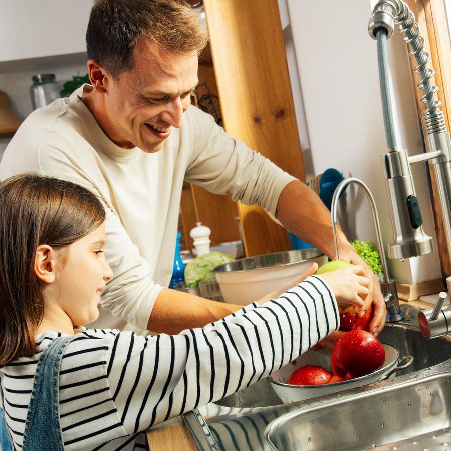 Padre e hija lavando fruta con agua filtrada