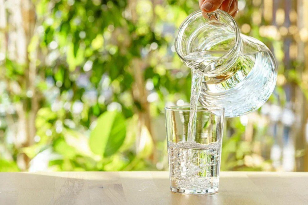 Vaso de agua filtrada sirviéndose desde el grifo